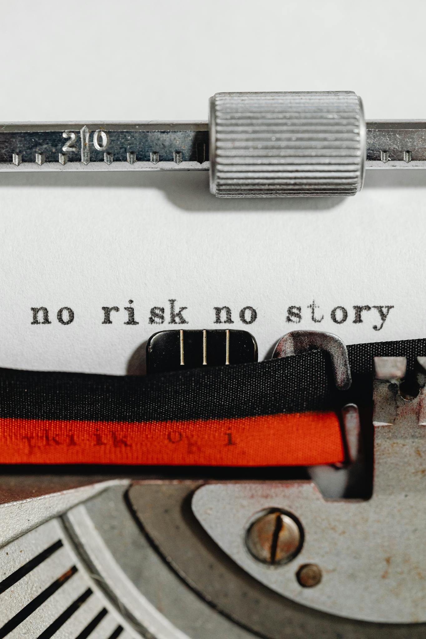 Close-up of a vintage typewriter with a motivational phrase 'no risk no story' typed on paper.